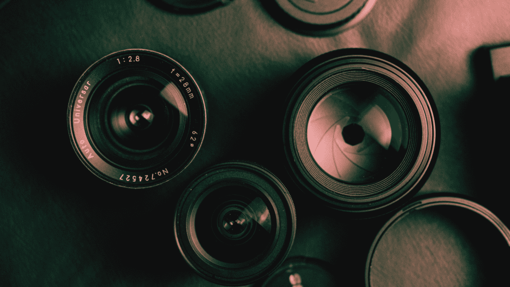 A variety of camera lenses on a dark surface